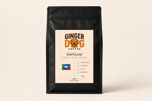 A black 1kg bag of Ginger Dog Coffee "Matilha" medium roast coffee displayed against a plain light background. The front label features the Ginger Dog Coffee logo, tasting notes of chocolate, caramel and dark fruit, and a Brazil-themed flag graphic. Icons indicate the coffee is suitable for whole bean, cafetière, filter and espresso brewing methods. The packaging is shown in a clear, front-facing product shot.