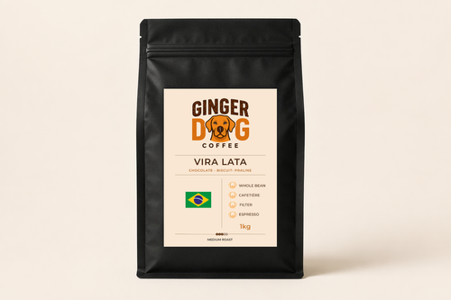 A black 1kg bag of Ginger Dog Coffee "Vira Lata" medium roast coffee displayed against a plain light background. The front label features the Ginger Dog Coffee logo, tasting notes of chocolate, biscuit and praline, and a Brazilian flag graphic. Icons indicate the coffee is suitable for whole bean, cafetière, filter and espresso brewing methods. The packaging is shown in a clean, front-facing product photograph.